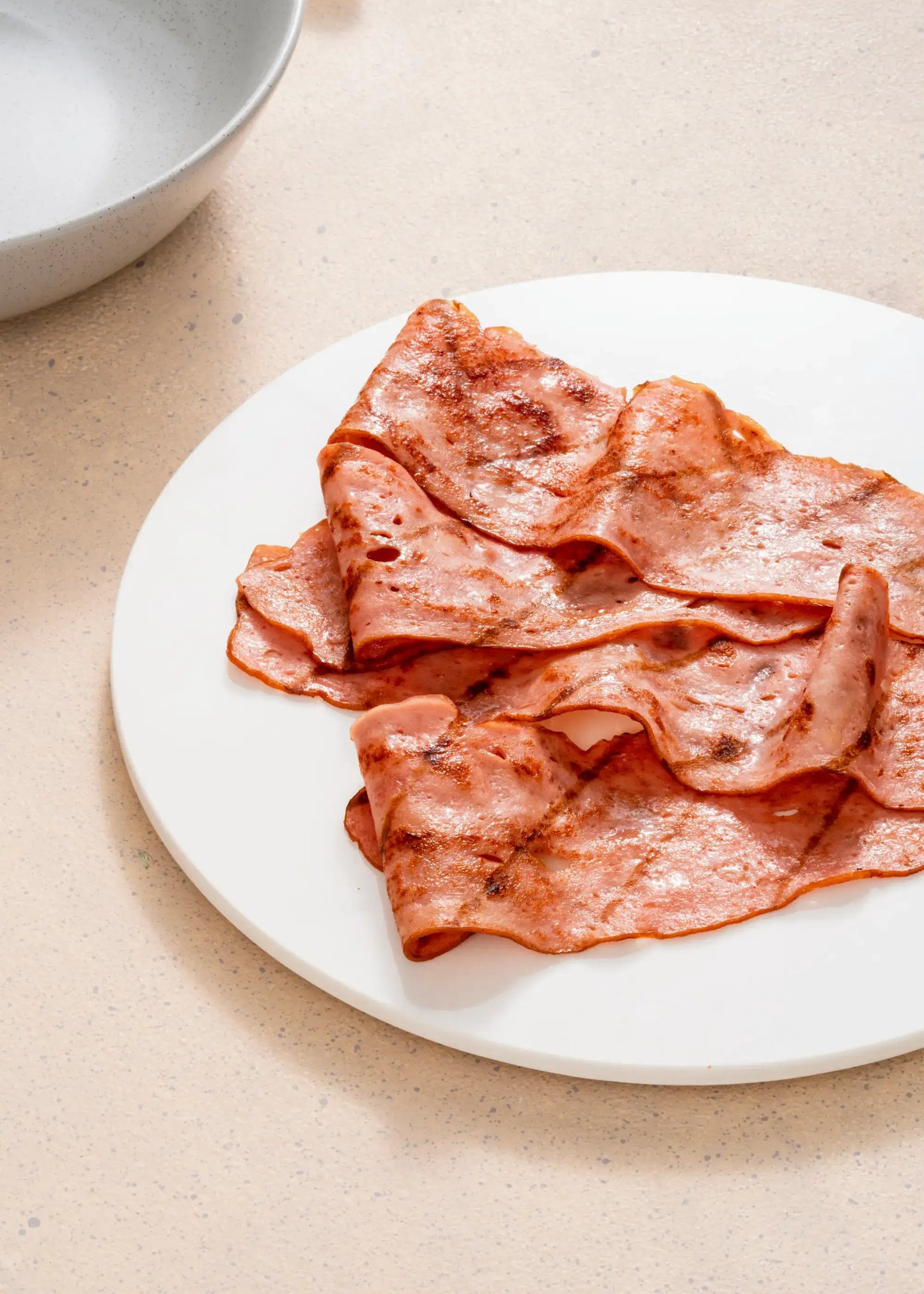 Rebanadas de Tocineta de Pavo Delipavo servidas en un plato blanco.